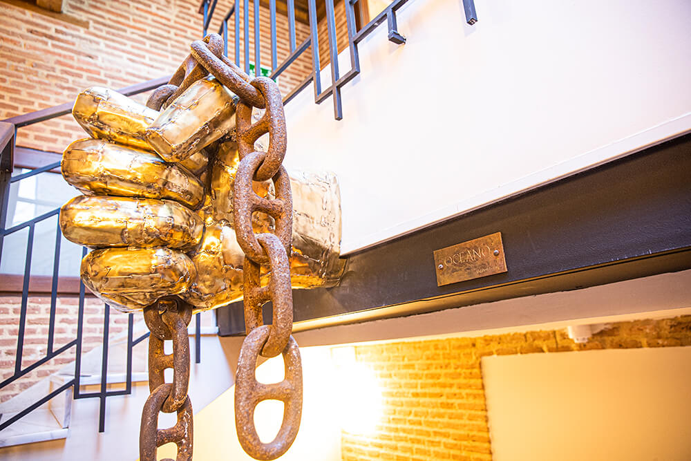 Camarote Hotel - escultura de mano sujetando cadena de metal